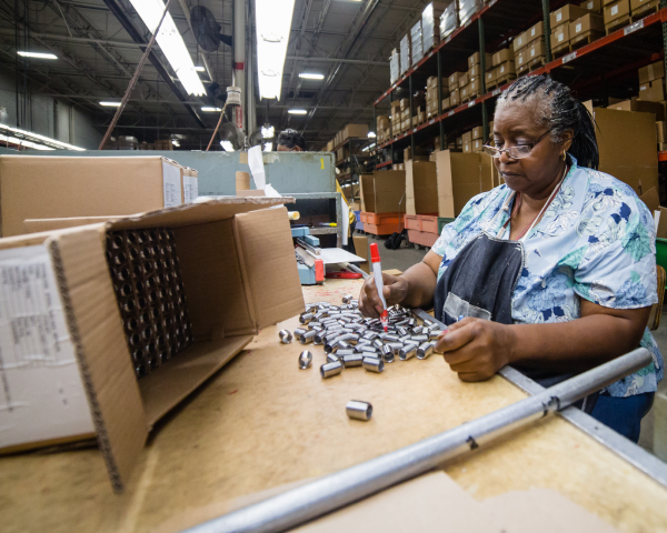 Merit Brass team member performing product inspection and packaging processes